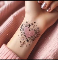 a woman's arm with a pink heart tattoo on her left side and stars around it