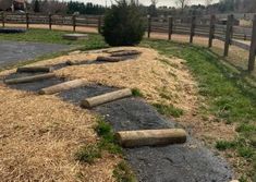 a set of steps made out of logs on the side of a dirt road in front of a fence