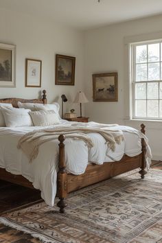 a bed with white sheets and pillows in a bedroom next to a window on a rug