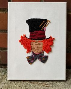 a white canvas with an orange and black top hat, bow tie and red hair