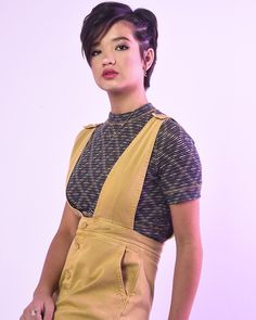 a woman with an apron on posing for the camera in front of a white background