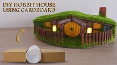 a cardboard box with a hobbot house on it next to a paper plate