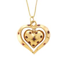 "This charming 14k yellow gold and Ruby pendant features two articulating hearts, both fashioned into a dome with a solid flat back. The inside heart is bead set with eight round Rubies; the inside heart dangles inside the center of the larger open heart, which has six bead-set, round Rubies. Perfect sentimental gift for your heart throb!   -  14k yellow gold  -  Outer Heart (frame): 1.13\" x 1.03\" x .17\" (28.80 wide x 26.30 long x 4.50mm deep) -  Inside Heart: .70\" x .63\" x .23\" (18.00 wide x 16.00 long x 5.80mm deep) -  Rubies: 14/0.03 to 0.06ct each, 0.62ctw (estimated due to mounting) -  Ruby color: Medium dark, very slightly brownish, slightly purplish red (slpR 6/3).  -  18\" Box Chain: 14k yellow gold (stamped), spring ring closure, .90mm wide  -  Total Weight: 10.34 grams comp Vintage Yellow Gold Heart Charm Necklace, Yellow Gold Pendant For Valentine's Day, Antique Heart-shaped Yellow Gold Jewelry, Vintage Yellow Gold Heart Necklace, Vintage Yellow Gold Heart Necklace For Valentine's Day, Antique Yellow Gold Heart Cut Jewelry, Heirloom Heart-shaped Yellow Gold Jewelry, Antique Yellow Gold Jewelry With Heart Charm, Antique Yellow Gold Heart Necklace