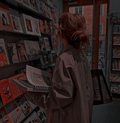 a woman standing in front of a book shelf filled with books