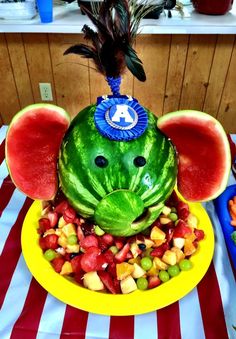 an elephant made out of watermelon on top of a plate filled with fruit