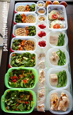 a table topped with lots of plastic containers filled with different types of vegetables and meats