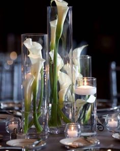 an image of a table setting with flowers in vases and candles on the table