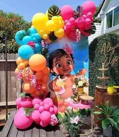 an outdoor birthday party with balloons and decorations on the back deck, including a large moan doll