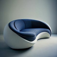 a blue and white couch sitting on top of a floor next to a wall in a room