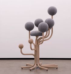 an art piece with three balls on it and a tree in the middle that is made out of wood