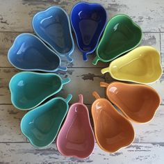 a circle of colorful dishes sitting on top of a white wooden floor next to each other