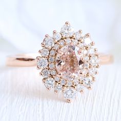 an engagement ring with a pink diamond surrounded by white diamonds