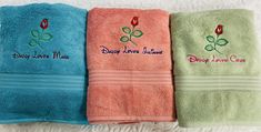 three towels with embroidered flowers on them