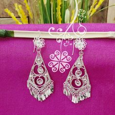 Beautiful and stunning handmade Mexican Filigree Earrings. Each piece is meticulously created out of copper wire and spun into a beautiful design. To give it the final touch artisans dipped into silver plate for it's elegant silver color. This accessory is an important part of the traditional Tehuana outfit from Oaxaca, Mexico. Look elegant while wearing Mexico's culture with this one of a kind earrings! Approximate length: 3.5-4 in Need more than one? Ask us about our combined flat rate shipmen Traditional Silver Dangle Clip-on Earrings, Silver Handmade Danglers For Party, Traditional Metal Dangle Clip-on Earrings, Traditional Silver Plug Earrings For Party, White Bohemian Earrings With Intricate Design, Bohemian Silver Bridal Earrings With Latkans, Bohemian Bridal Earrings With Latkans In Silver, Bohemian Bridal Silver Earrings With Latkans, Ornate White Dangle Earrings