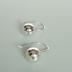 A PAIR of sterling silver ball danglers. These earrings are made of 925 hypoallergenic sterling silver. Size: 10 mm Drop length: 21 mm Weight: 2.5 gm All my pieces are sent in a gift box. I can include a personal message from you if needed. You are welcome to contact me at... bhavnakwintra1956@gmail.com More hoops: https://www.etsy.com/your/shops/TheSilverGame/tools/listings/section:26305414 More earrings: https://www.etsy.com/your/shops/TheSilverGame/tools/listings/section:26308789 Ear climbers Silver Dainty Earrings Simple Design, Dainty Silver Earrings With Simple Design, Simple Silver Round Earrings, Simple Sterling Silver Earrings As Gift, Sterling Silver Simple Design Earrings For Gift, Elegant Sterling Silver Earrings With Simple Design, Simple Round Silver Earrings, Classic Sterling Silver Earrings With Simple Design, Silver Sphere Earrings For Pierced Ears