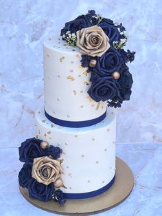 two tiered wedding cake decorated with blue and gold flowers