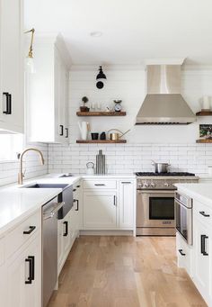 the kitchen is clean and ready for us to use it's white cabinets, wood floors, and stainless steel appliances