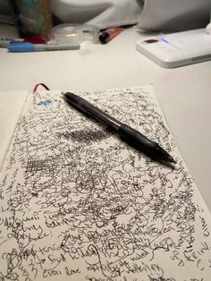 a pen sitting on top of a piece of paper with writing all over the page