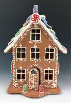 a ceramic gingerbread house with candy on the roof