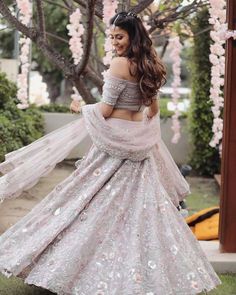 a woman in a white and silver lehenga