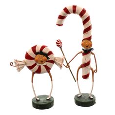 two small figurines are holding candy canes