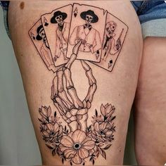 a woman's thigh with playing cards and flowers on it