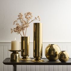 gold vases and candles sit on a table