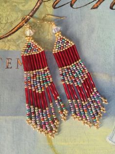 red and gold beaded earrings on top of a table