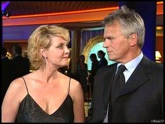 a woman in a black dress and a man in a suit talking to each other