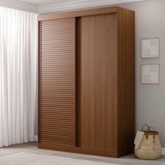 a room with a large wooden closet next to a white curtained window and rug