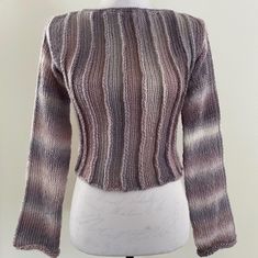 a white mannequin wearing a purple and black sweater