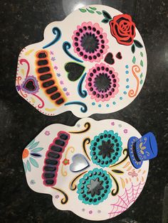 two sugar skulls decorated with flowers and hearts