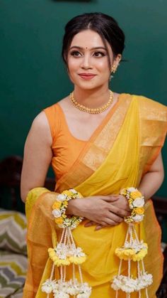 a woman in yellow sari with flowers on her chest