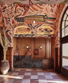 an ornately decorated lobby with tiled flooring and wood paneled walls, along with potted cacti