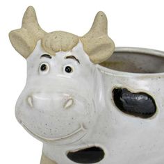 a ceramic cow mug with horns sticking out of it's mouth and eyes, sitting in front of a white background