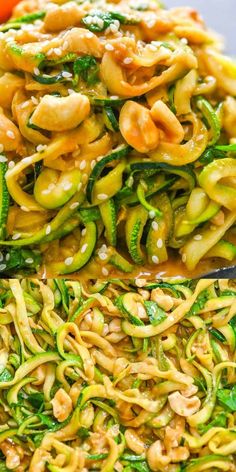 noodles and vegetables are being cooked in a wok