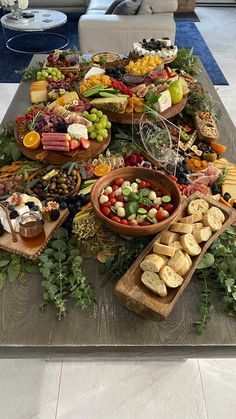 a table filled with lots of different types of food on top of wooden trays