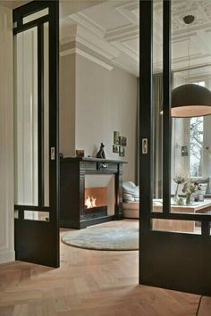 an open door leading to a living room with a fireplace