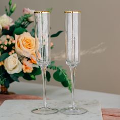 two champagne flutes sitting on top of a table