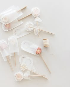 several lollipops and cotton swabs are arranged on a white surface