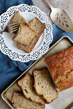 slices of banana bread sitting on top of a pan next to a fork and spoon