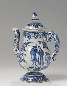 a blue and white teapot with figures on it