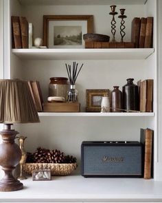 the shelves are filled with books, candles and other decorative items on top of them