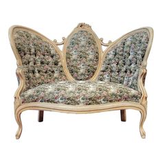 an ornately decorated couch with floral upholstered fabric on the back and arms