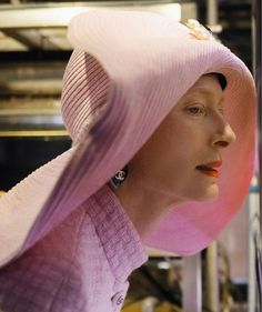 a woman wearing a pink hat and looking off into the distance