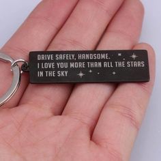 a hand holding a keychain that says drive safely, handsome i love you more than all the stars in the sky