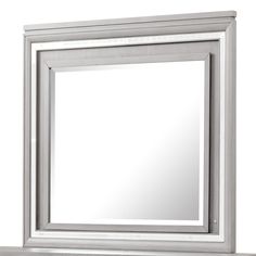 a silver framed mirror sitting on top of a shelf