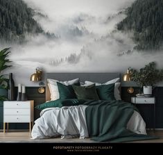 a bedroom decorated in green and white with a mountain mural on the wall behind it