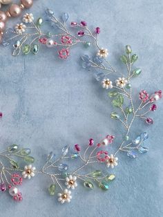 several different colored beads and pearls on a blue surface with one bead in the middle