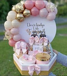 a basket filled with lots of pink and gold items on top of a grass covered field